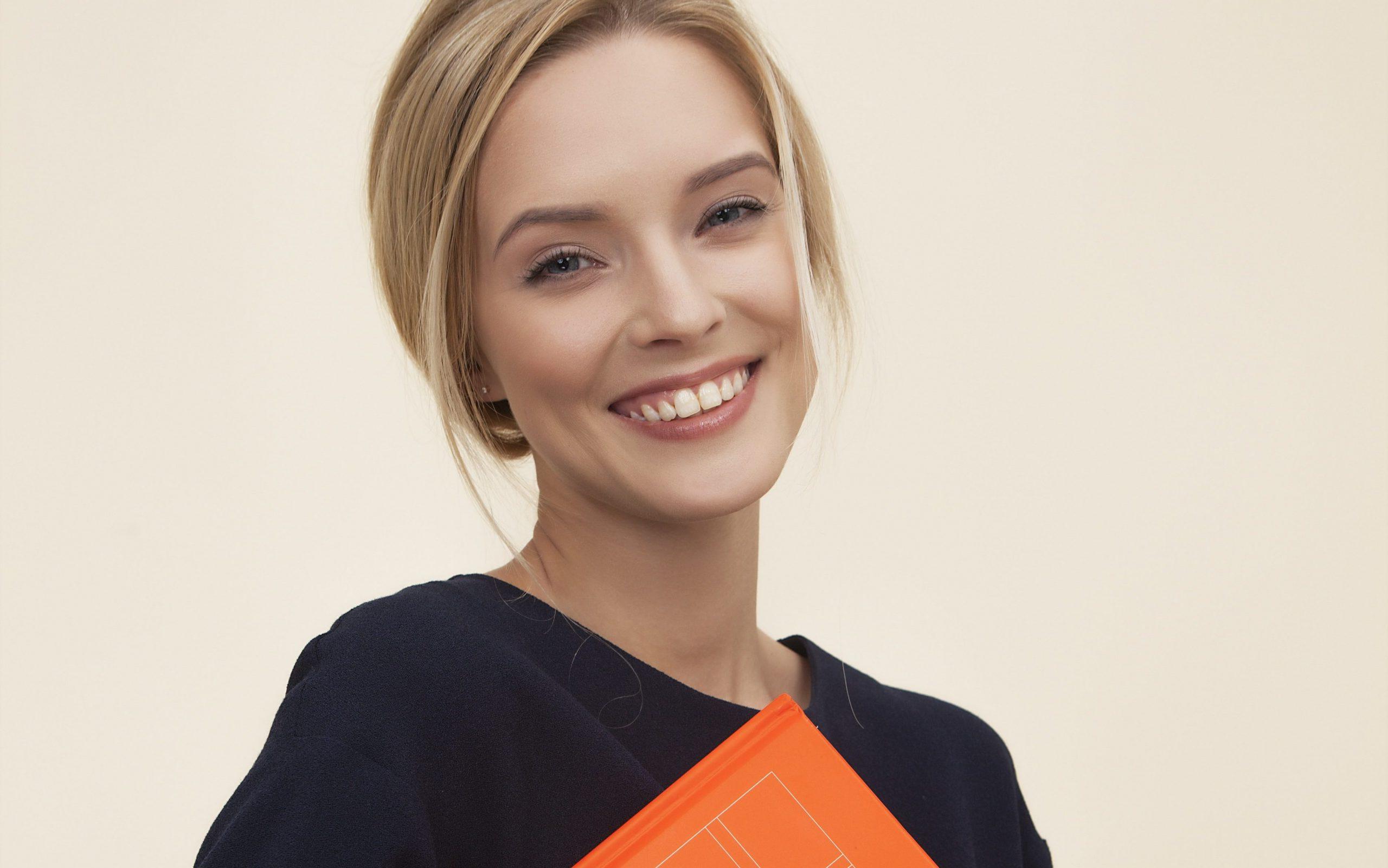 white young woman holding orange folder